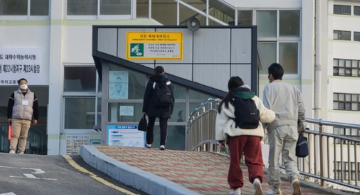 2023학년도 대학수학능력시험일인 17일 오전 부산 동래구의 한 고사장에서 한 학부모가 수험생인 딸의 손을 잡고 입구까지 배웅하고 있다. (사진=뉴시스 제공)