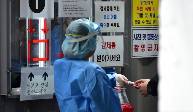  지난 14일 오후 대구 수성구보건소 코로나19 PCR 선별진료소에서 의료진이 검체통을 건네고 있다. (사진=뉴시스)