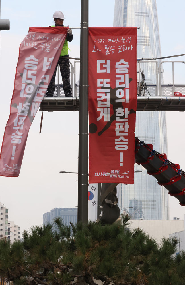작업자들이 지난 21일 오후 서울 송파구 올림픽로에서 월드컵 응원 현수막을 설치하고 있다. (사진=뉴시스 제공)