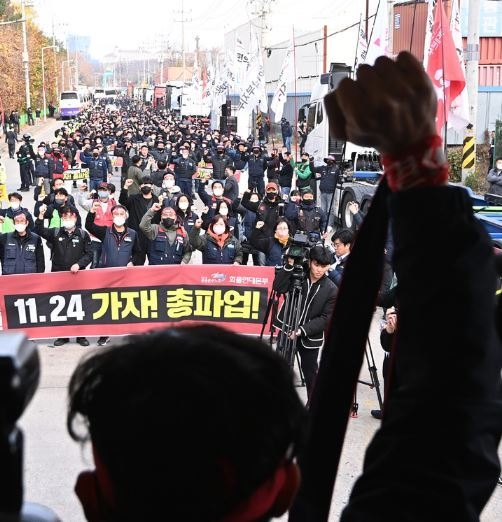 민주노총 공공운수노조 화물연대 조합원들이 24일 경기도 의왕시 내륙컨테이너기지(ICD)에서 열린 '총파업 출정식'에서 안전운임제 일몰제 폐지 등을 요구하며 구호를 외치고 있다. (사진=뉴시스 제공)
