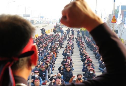 민주노총 공공운수노조 화물연대 인천지역 본부가 안전 운임 일몰제 폐지를 요구하며 총파업에 돌입한 24일 오전 인천 연수구 인천신항 컨테이너 터미널 앞에서 인천지역 본부 조합원들이 출정식을 열고 구호를 외치고 있다. (사진=뉴시스 제공)