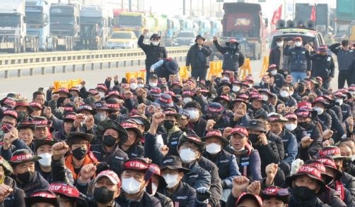 민주노총 공공운수노조 화물연대본부가 안전 운임 일몰제 폐지를 요구하며 총파업에 돌입한 24일 오전 인천 연수구 인천 신항 컨테이너 터미널 앞에서 인천지역본부 조합원들이 출정식을 열고 구호를 외치고 있다. (사진=뉴시스 제공)