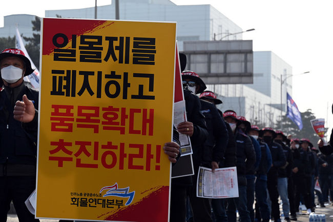 민주노총 공공운수노조 화물연대 충남지역본부 소속 조합원이 24일 당진시 송악읍 현대제철 정문 앞에서 일몰제 폐지와 차종·품목 확대를 요구하는 팻말을 들고 있다. (사진= 민주노총 공공운수노조 화물연대 제공) 