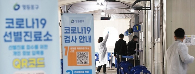  0시 기준 코로나19 신규확진자가 5만9089명 발생한 지난 24일 오전 서울 영등포보건소 선별진료소에서 시민들이 검사를 위해 안내받고 있다.
