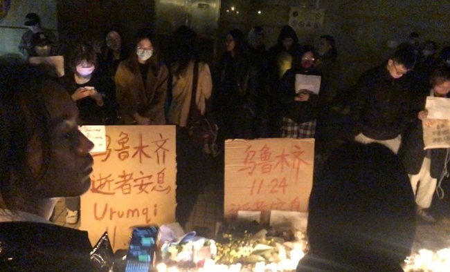 11월 26일 밤 (현지시간) 중국 상하이 시내의 코로나19봉쇄 반대 시위대가 중국 신장의 한 아파트 화재로 숨진 10명의 영혼을 위로하는 집회를 갖고 있다. 