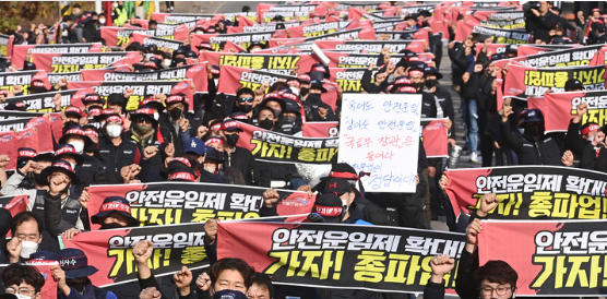 민주노총 공공운수노조 화물연대 조합원들이 24일 경기도 의왕시 내륙컨테이너기지(ICD)에서 열린 '총파업 출정식'에서 안전운임제 일몰제 폐지 등을 요구하며 구호를 외치고 있다. (사진=뉴시스 제공)