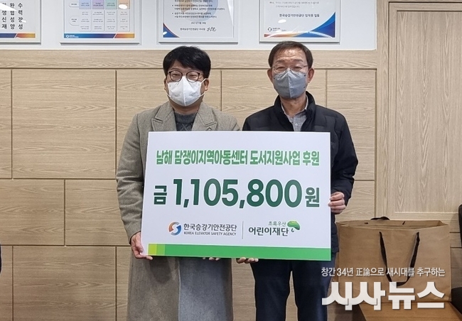 한국승강기안전공단 양의모 경영기획이사가 초록우산어린이재단을 통해 남해 담장이지역아동센터 도서지원사업 후원금을 전달하고 있다.<br>