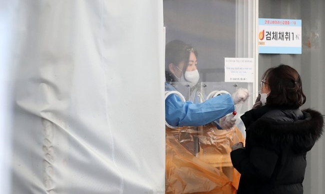 지난 22일 오후 서울 중구 서울역광장에 마련된 임시선별검사소에서 의료진이 검체를 채취하고 있다. 