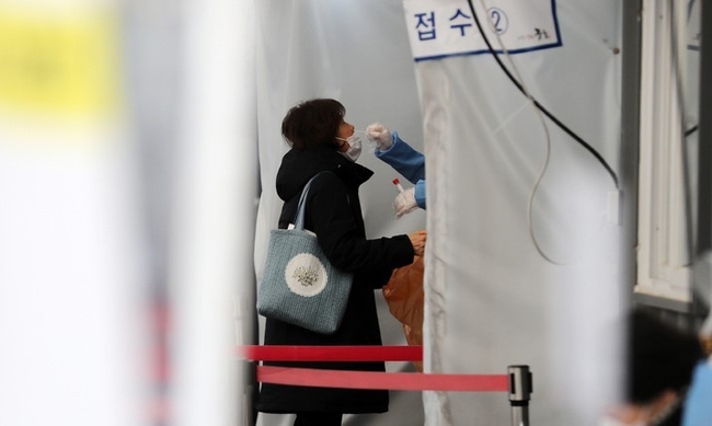  지난 22일 오후 서울 중구 서울역광장에 마련된 임시선별검사소에서 한 시민이 PCR검사를 받고 있다. (사진=뉴시스)