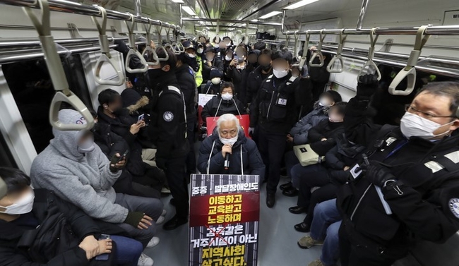 박경석 전국장애인차별철폐연대(전장연) 대표가 지난 20일 오전 서울 광화문역에서 지하철에 탑승해 장애인 권리 예산 보장을 촉구하는 출근길 선전전을 하고 있다. (사진=뉴시스)