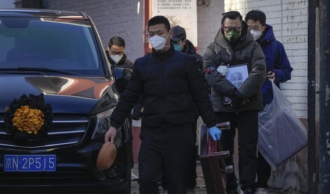 19일 중국 베이징의 한 발열 전담병원에서 사람들이 영정사진과 장례용품 등을 들고 운구차량 옆을 지나고 있다. (사진=뉴시스)