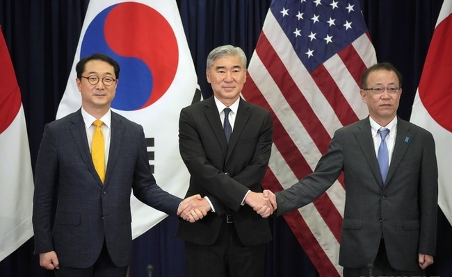 김건(왼쪽) 외교부 한반도평화교섭본부장이 13일(현지시간) 인도네시아 자카르타에 있는 미국 대사관에서 열린 한미일 북핵수석대표 협의에 참석해 성 김(가운데) 미 국무부 대북특별대표, 후나코시 다케히로 일본 외무성 아시아·대양주국장과 손을 잡고 있다.