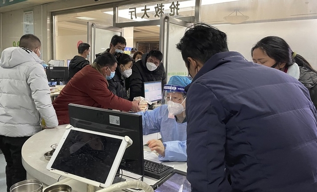 지난 22일 중국 허베이성 바저우에 있는 랑팡 4호 병원 응급실에 방문객들이 직원에게 말하고 있다. (사진=뉴시스 제공)