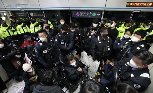 지난 3일 오전 서울 지하철 4호선 동대문역사문화공원역 승강장에서 전국장애인차별철폐연대(전장연) 회원들이 254일차 장애인 권리예산 입법 쟁취 지하철 선전전을 위해 탑승하려던 중 저지하는 서울지하철공사 직원 및 경찰들에게 가로막혀 있다. 전장연은 이날 4호선 성신여대입구 역에서 탑승했다가 동대문역사문화공원 역에서 하차했다. 다시 탑승하고 삼각지역으로 향해 집회를 이어가려고 했으나 교통공사와 경찰의 탑승 저지로 이동하지 못하고 있다. (사진=뉴시스 제공)