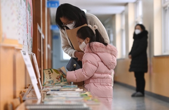 초등학교 예비소집일인 지난해 12월26일 오후 경기도 수원시 장안구 송원초등학교에서 입학을 앞둔 어린이가 엄마와 함께 교과서를 살펴보고 있다. (사진=뉴시스)