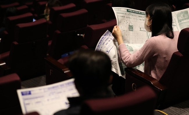 지난달 19일 오후 서울 송파구 롯데시네마 월드타워점에서 열린 2023학년도 대입 정시 입시전략 설명회에서 수험생과 학부모들이 지원가능 대학·학과 참고자료를 살펴보고 있다.(사진=뉴시스)