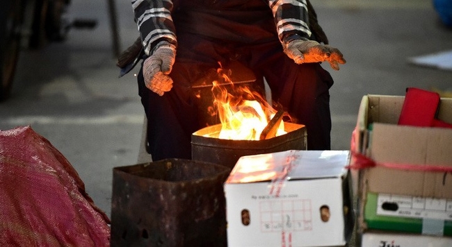 전국에 기온이 뚝 떨어지며 추운날씨를 보인 지난 25일 오전 대구 북구 칠성시장에서 한 상인이 모닥불을 쬐고 있다. (사진=뉴시스)
