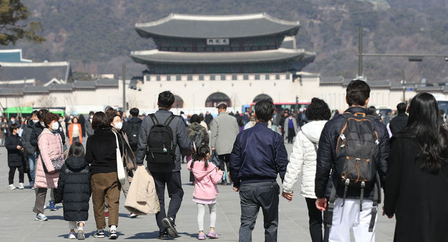 낮 최고기온 11도로 포근한 날씨를 보인 27일 서울 광화문 광장에서 시민들이 두꺼운 외투를 벗어 들고 걸어가고 있다.(사진=뉴시스 제공)