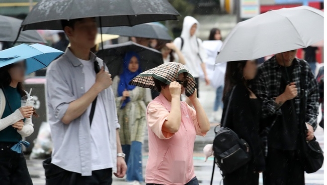 비가 내리는 18일 오후 서울 신촌 거리에서 한 시민이 손수건을 머리에 쓰고 이동하고 있다. (사진=뉴시스 제공)