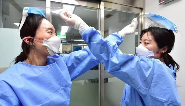 지난 1일 대구 중구 계명대학교 대구동산병원에서 코로나격리병동 간호사들이 근무교대 후 서로의 페이스쉴드를 벗겨주고 있다. (사진=뉴시스)