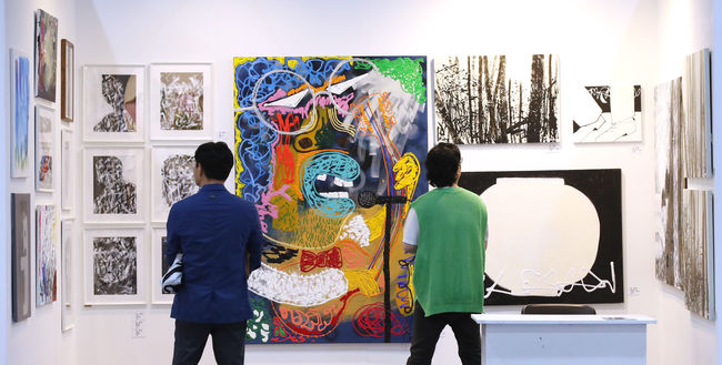 제2회 서울아트페어에서 관람객들이 가수 겸 탤런트인 화가 김창완의 미술 작품을 보고 있다.
