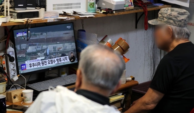 일본이 후쿠시마 오염수 방류를 시작한 24일 오후 서울 동작구 노량진수산시장에서 상인들이 관련 뉴스를 시청하고 있다. (사진=뉴시스 제공)