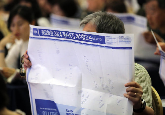 수험생 학부모들이 7월 23일 서울 광진구 세종대학교 광개토관 컨벤션홀에서 열린 ‘종로학원 2024대입 수시정시 합격 예상 점수 공개 및 수험생 지원전략 설명회’애서 배치표를 살펴보고 있다.