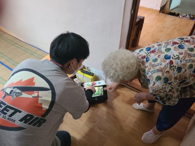 천안시 관계자가 응급안전안심서비스를 설치하고 대상 어르신에게 응급호출 사용방법을 설명하고 있다. (사진=천안시 제공)