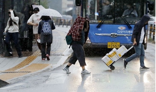 비가 내리고 있는 지난 4일 오후 서울 명동성당 인근 거리에서 우산을 챙기지 못 한 시민들이 황급히 이동하고 있다. (사진=뉴시스 제공)