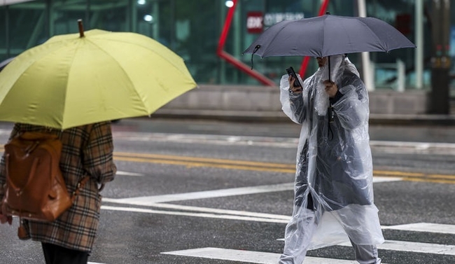 비가 내린 지난 5일 서울 강남구 강남역 인근에서 한 시민이 우비를 입은 채 우산을 들고 이동하고 있다. (사진=뉴시스 제공)