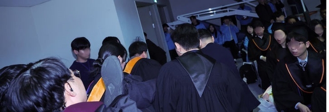 16일 대전 유성구 카이스트(KAIST)에서 열린 2024년 학위수여식에서 석사 졸업생이 R&D 예산 복원 등을 요구하며 자리에서 일어나 항의하던 중 제지 당하며 끌려나가고 있다. (사진=뉴시스 제공)