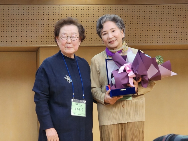 한국수필문학진흥회 맹난자 고문으로부터 대상을 수상하고 함께 포즈를 취하고 있는 최민자수필가(사진 오른쪽). (사진제공=최민자수필가)