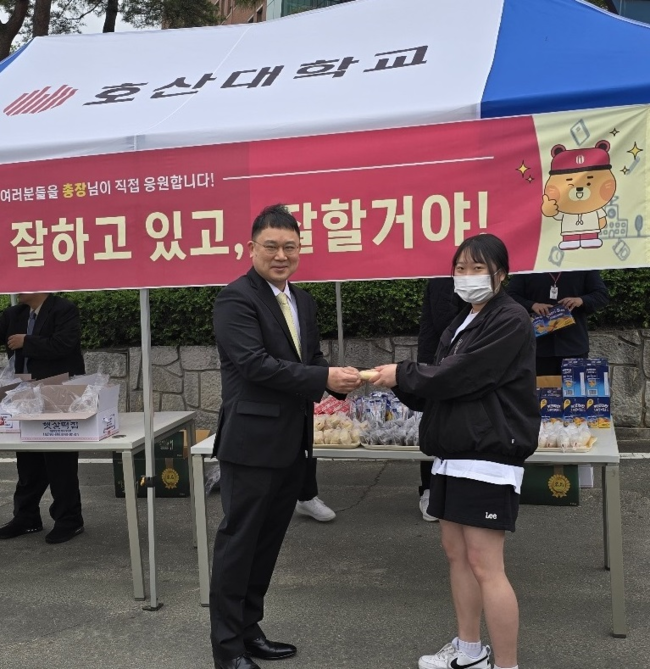 떡나눔 행사에서 준비한 떡과 음료를 김재현 총장이 직접 나눠주며 재학생들을 응원했다.(사진=호산대 제공)