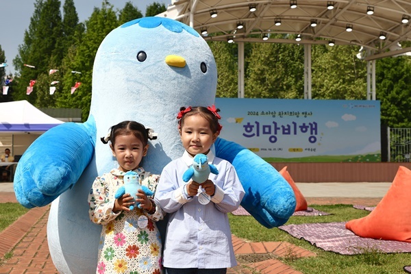 지난 27일(토) 서울 강남구 일원동 마루공원에서 소아암 어린이 완치 희망행사에 참여한 어린이들이 새마을금고 블루원정대 캐릭터 미루와 사진촬영을 하고 있다(사진=새마을금고중앙회 제공)