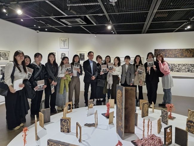 유근택 작가와 성신여대 제자들이 성북구립미술관 제2전시실에서 목판 작품을 감상하고 있다. <사진=이화순>