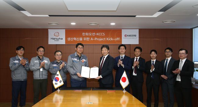 한화오션 조선소장 이길섭 부사장(왼쪽에서 네번째)이 교세라社의 마츠나가 카즈히로 사업부장(왼쪽에서 다섯번째)과 계약서에 서명하고 기념 촬영하는 모습.(사진=한화오션 제공)