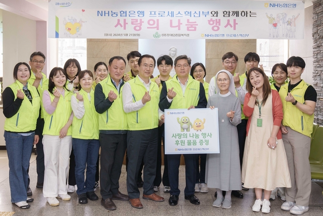 NH농협은행은 21일 서울 성동구 소재 성동장애인복지관을 방문해 후원물품 전달 및 봉사활동을 실시했다. 최성자 성동장애인종합복지관 관장(푯말 든 오른쪽)과 정재호 디지털전략사업부문 부행장(푯말 든 왼쪽) 및 농협은행 프로세스혁신부 직원들이 기념사진을 촬영하고 있다. (사진=NH농협은행 제공)