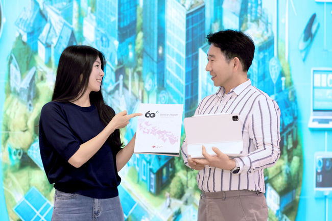 LG유플러스는 향후 상용화될 6G 이동통신 서비스를 전망하는 ‘6G 백서-앰비언트 IoT’를 발간했다. 사진은 LG유플러스 직원들이 새로 발간된 6G 백서를 소개하고 있는 모습.(사진=LG유플러스 제공)