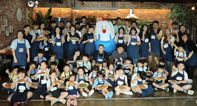 피오봉사단 11기 임직원 및 소비자 가족이 쿠킹클래스에서 만든 치킨피자와 닭목살 덮밥을 들고 기념촬영을 하고 있다.(사진=하림 제공)
