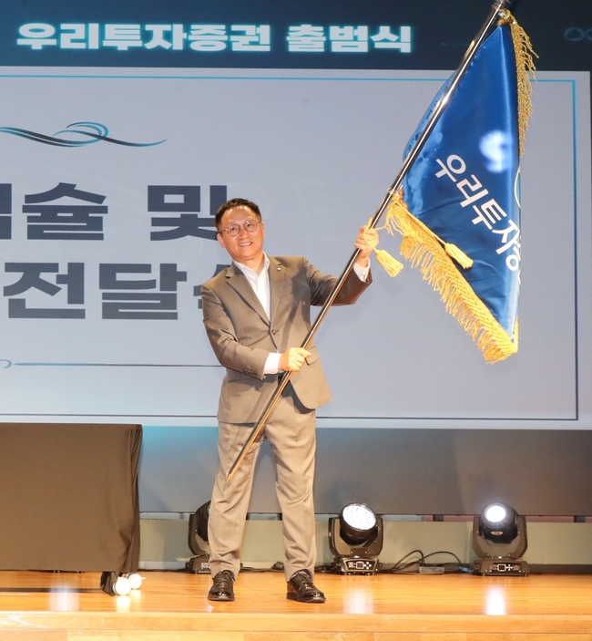 남기천 우리투자증권 대표가 회사기를 흔들고 있다. (사진=우리투자증권 제공)