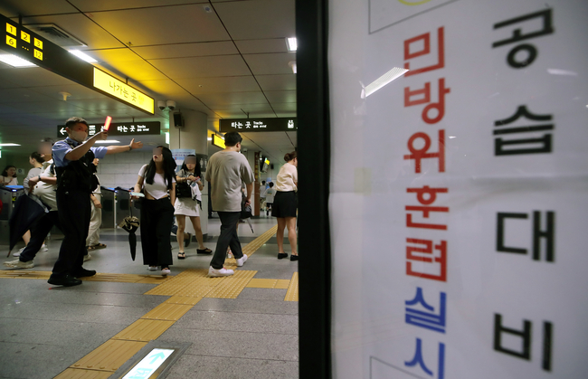 2023년 8월 23일 을지연습 공습대비 민방위훈련 당시 경보가 울리자 서울시청역 환승통로에서 서울교통공사 직원 안내에 따라 시민들이 대피하고 있다. (사진=뉴시스 제공)