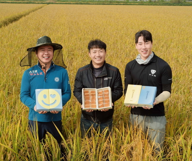 경기도 평택시에 위치한 가루쌀 농가에서 농업인들이 가루쌀을 원료로 활용한 파리바게뜨의 샌드쿠키를 들고 기념 촬영을 하고 있다. (사진=파리바게뜨 제공)