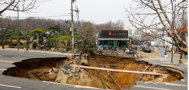 25일 서울 강동구 명일초등학교 인근 도로에서 전날 발생한 싱크홀(땅 꺼짐) 사고 현장 모습. (사진=뉴시스 제공)