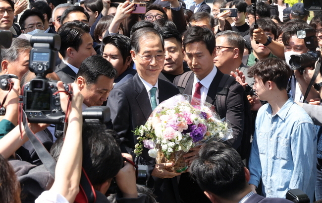한덕수 전 국무총리가 2일 오전 서울 여의도 국회 소통관에서 대선출마 선언 기자회견을 마치고 지지자에게 꽃다발을 받고 있다. 