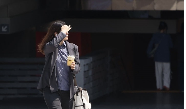 지난 20일 오후 서울 종로구 광화문 광장에서 외국인 관광객이 손으로 햇빛을 가리고 길을 걸어가고 있다.(사진=뉴시스 제공)