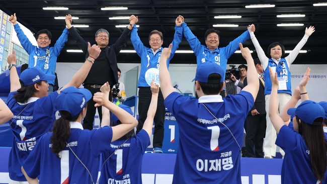 이재명 더불어민주당 대선 후보와 참석자들이 24일 경기 안산 단원구 안산문화광장에서 열린 유세에서 손을 잡고 시민들에게 인사하고 있다.(사진=뉴시스 제공)