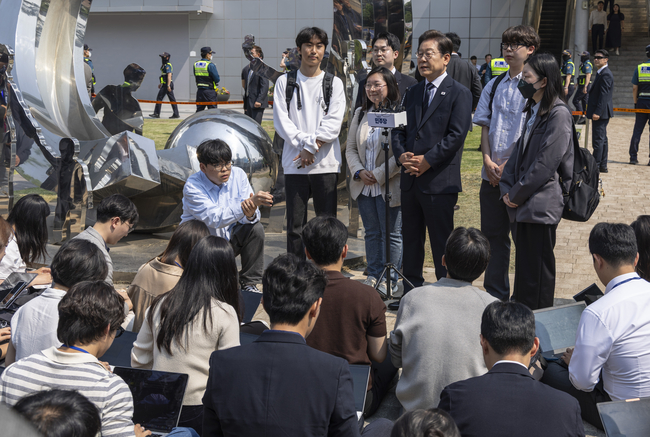 이재명 더불어민주당 대선후보가 제21대 대통령 선거 사전투표 첫날인 29일 오전 서울 서대문구 신촌동 주민센터 투표소에서 청년들과 함께 사전투표를 마치고 취재진의 질문에 답변하고 있다.(사진=공동취재/뉴시스 제공)
