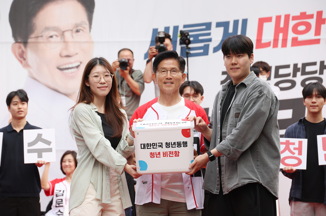 김문수 국민의힘 대선 후보가 1일 서울 서대문구 신촌역 인근에서 열린 집중유세에서 청년들로부터 청년비전함을 받고 있다.(사진=공동취재/뉴시스 제공)