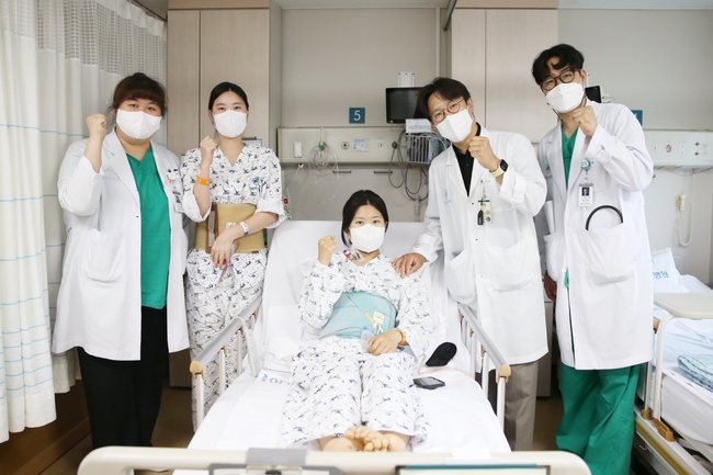 <strong>다낭성 신증후군으로 만성 신부전을 앓던 이가영 씨(가운데)가 로봇 신장이식 후 순조롭게 회복하며 20일(금) 의료진과 기념사진을 찍고 있다. (사진=서울아산병원 제공)</strong><br>
