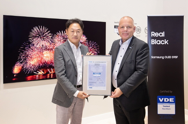 삼성전자 설훈 독일 CE Division장(왼쪽)과 안스가르 힌즈(Ansgar Hinz) VDE CEO(오른쪽)가 지난 5일 독일 베를린 IFA 2025 삼성전자 행사장에서 진행된 리얼 블랙 인증 수여식에서 기념 촬영을 하고 있다.(사진=삼성전자 제공)